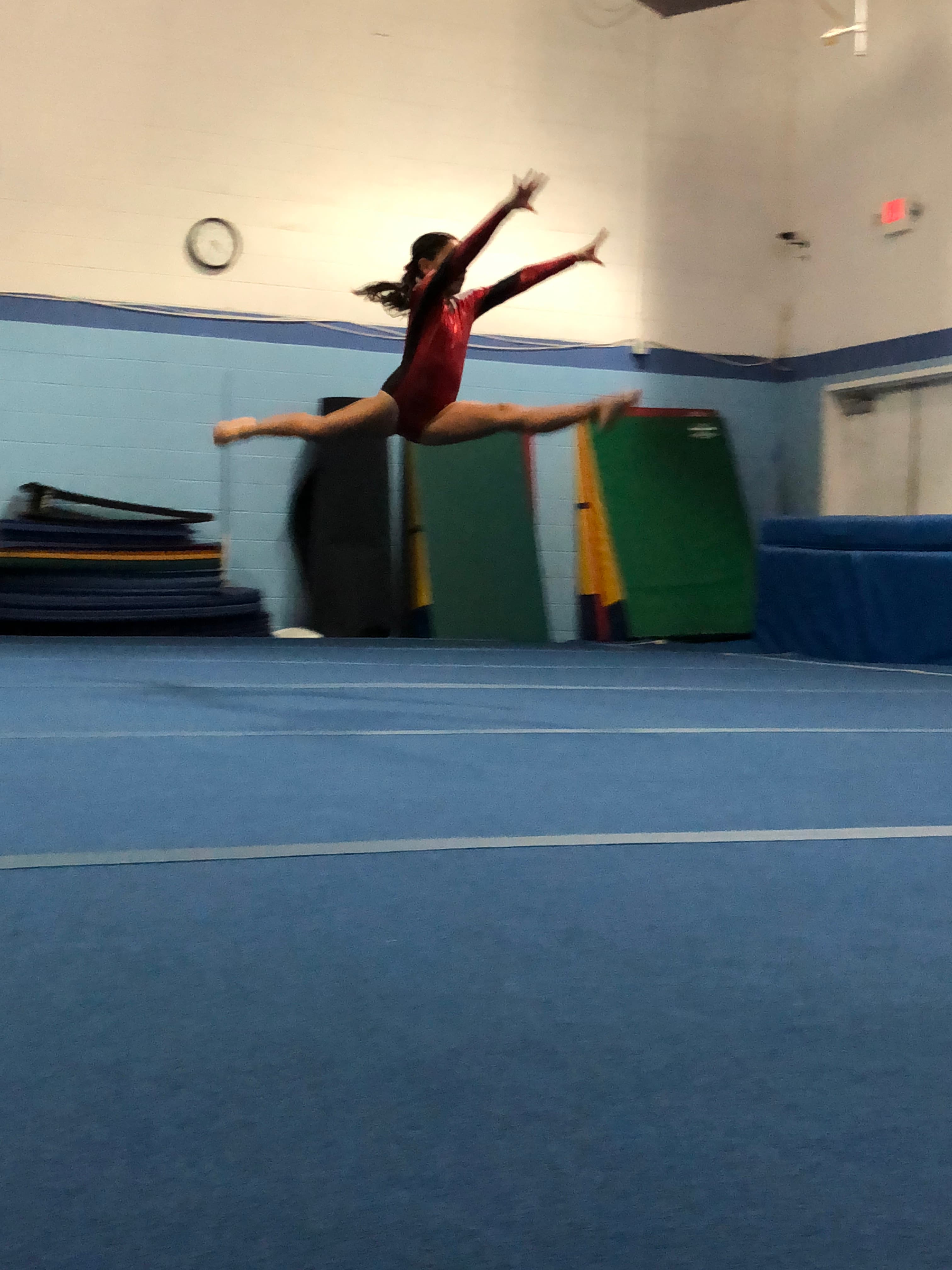 El Paso Gymnastics athlete leaping on the floor exercise