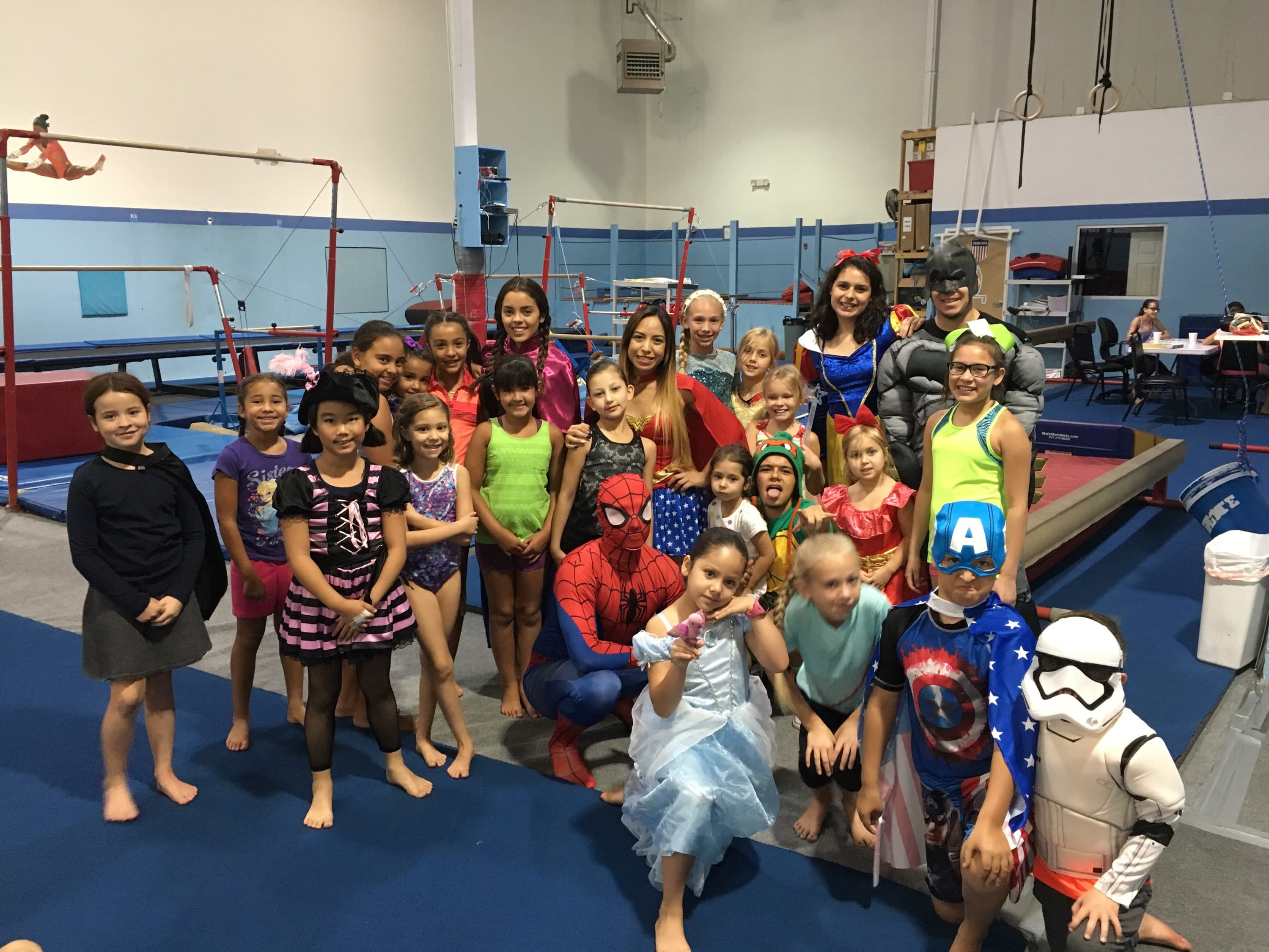 Kids and coaches in costumes at an El Paso Gymnastics Kids Night Out event